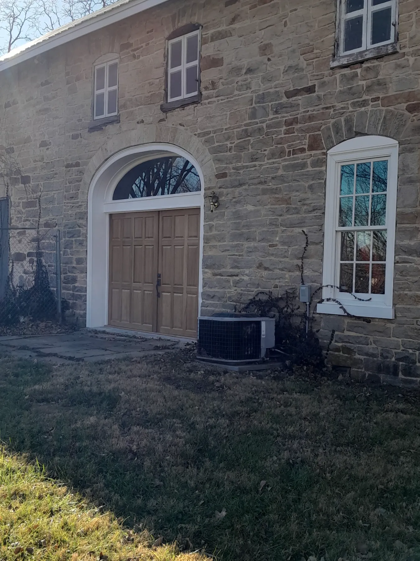Arched wooden doors set into the sandstone wall